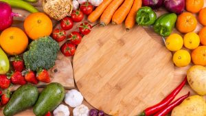 Discover a vibrant assortment of fresh fruits and vegetables arranged on a wooden board. Perfect for healthy eating inspiration.