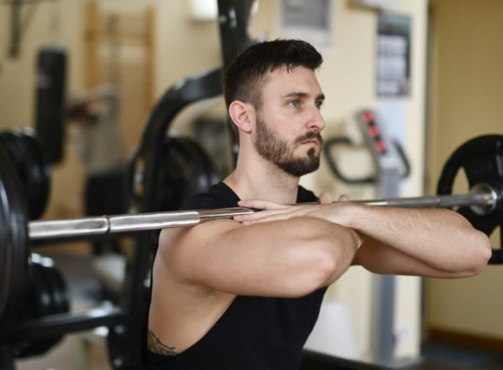 A focused man lifting weights indoors showcasing strength and concentration.